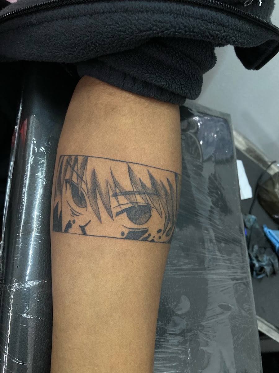 Black and gray anime style tattoo band on a forearm